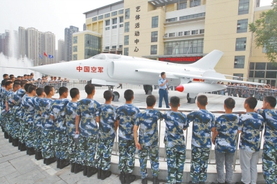 航空实验班的学生在强5飞机前听教官介绍航空知识