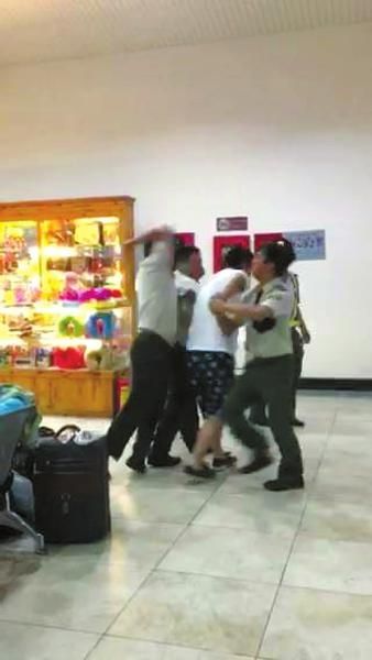 越南边检人员将一名中国男游客抓住，一名边检人员还有肘击其背部的动作。本组图片均据网友