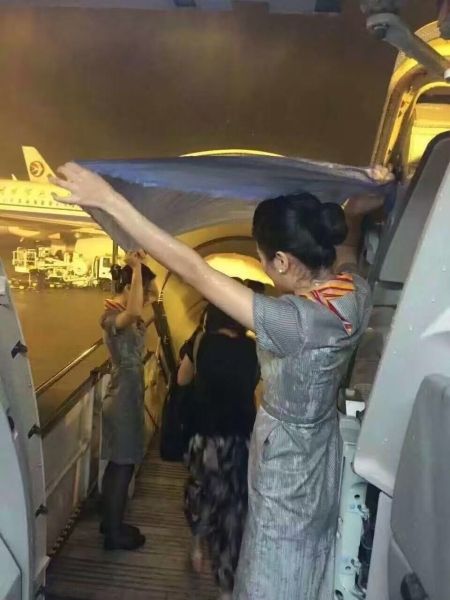 姑娘们愿意徒手为旅客在雨中撑起一条走廊