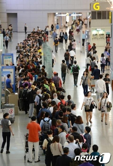 资料图:仁川机场排长队等待安检的乘客。(news 1)