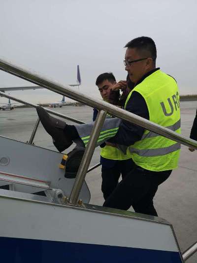 图:胡书源与同事合力抬起轮椅旅客.jpg