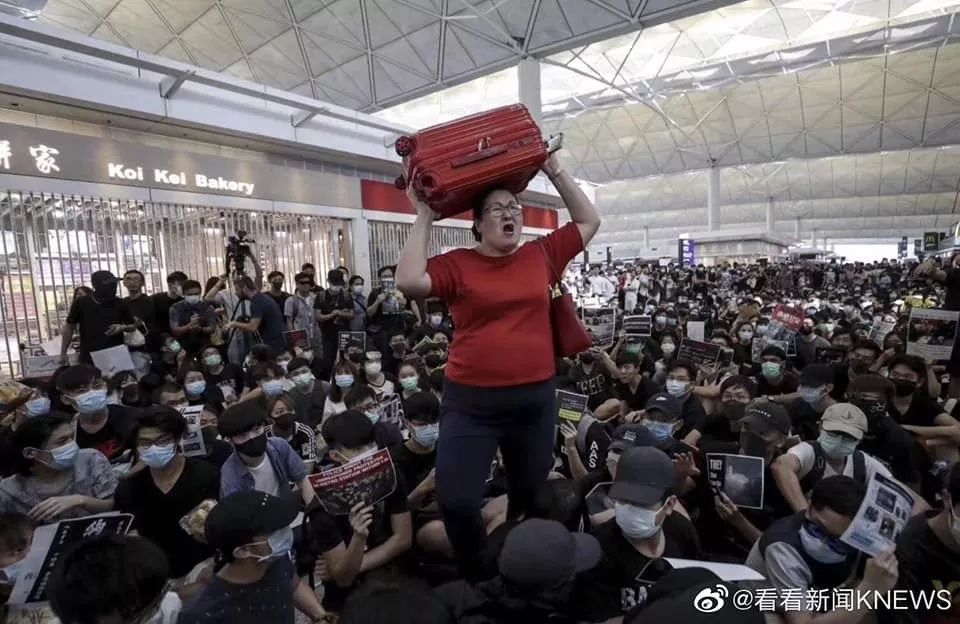 面对香港机场满地示威者 新加坡红衣女子冲了出去503439_ 面对香港机场满地示威者 新加坡红衣女子冲了出去